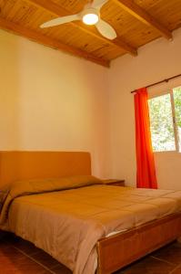 een slaapkamer met een bed met een plafondventilator bij Quinta El Oasis in Junín