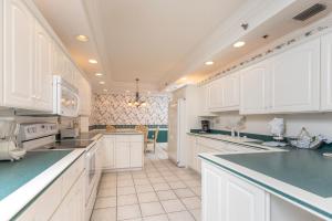a kitchen with white cabinets and green counter tops at Phoenix East 1401 in Orange Beach +84 photos