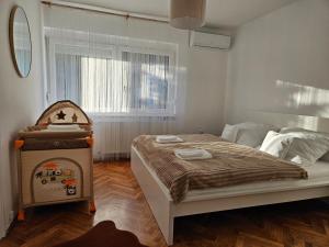 een slaapkamer met een groot bed en een raam bij FAMILLE Apartman in Tapolca