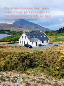 a white house with a car parked in front of it at Croi An Locha in Achill Island