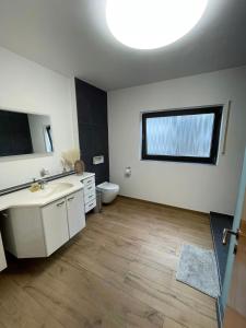 een badkamer met een wastafel en een toilet bij Pension Zum Waldrand in Sinsheim