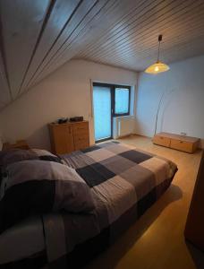 a bedroom with a large bed and a window at Pension Zum Waldrand in Sinsheim +14 photos