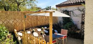 un parasol et une table dans un jardin dans l'établissement Jonadam, à Saint-Julien-de-Lampon