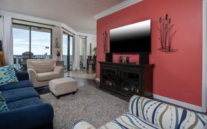 a living room with a blue couch and a tv at Phoenix East 1405 in Orange Beach