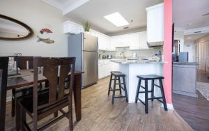 a kitchen with a table and chairs and a refrigerator at Phoenix East 1405 in Orange Beach