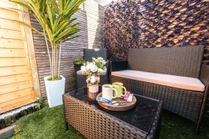 een terras met een tafel, mokken en een stoel bij Hot Tub & Sauna Retreat , 4BR with Free Parking in Portsmouth