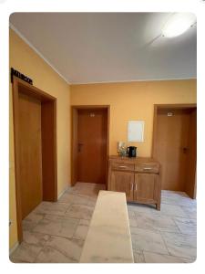 een lege kamer met een tafel en twee deuren bij Pension Zum Waldrand in Sinsheim +6 foto's