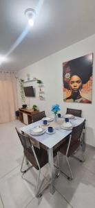 een eetkamer met een tafel met stoelen en een schilderij bij Pedacinho de Lar in João Pessoa