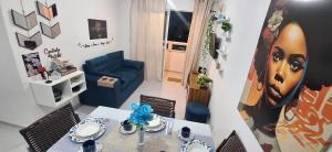 a living room with a table and a blue couch at Pedacinho de Lar in João Pessoa
