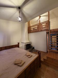a bedroom with a bed with wooden floors and a fireplace at Chalet Vasilitsa in Grevena
