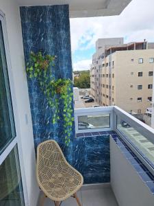 a chair sitting on a balcony with a mural at Pedacinho de Lar in João Pessoa