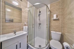a bathroom with a shower and a toilet and a sink at Chapel Road Cosy Rooms & Studios in Hounslow +37 photos