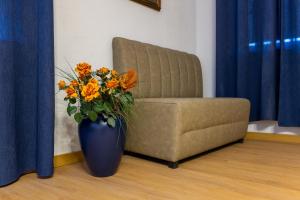 a blue vase with orange flowers in front of a chair at Schloss Höfingen in Leonberg +17 photos