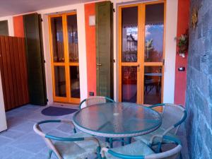 ein Glastisch und Stühle auf einer Terrasse in der Unterkunft Bernina House in Chiesa in Valmalenco