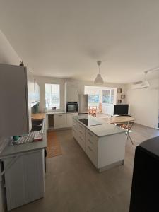 a large kitchen with white cabinets and a table at Villetta Brasi in Celle Ligure