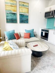 een woonkamer met twee banken en een salontafel bij Cayman Convenient Stay at Harbour Walk in Red Bay Estate