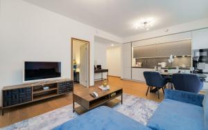 a living room with a blue couch and a tv at Lodja Suites in Tartu