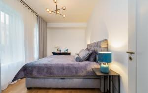 a bedroom with a bed with a blue lamp on a table at Lodja Suites in Tartu