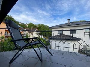 a chair sitting on the balcony of a house at Pension am Waldrand in Sinsheim