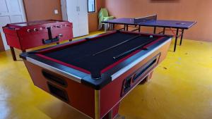 two ping pong tables in a room with a pool table at Ashley's Cottage in Himeville