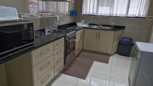 a kitchen with a stove top oven next to a sink at Ashley's Cottage in Himeville