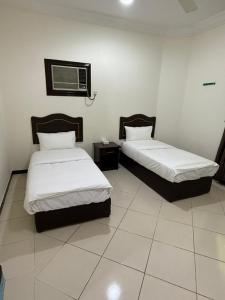 a room with two beds and a air conditioner at شقة مفروشة بحي النسيم in Mecca