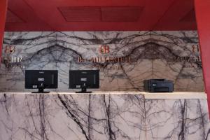 a counter with three computer monitors on a marble wall at BA Millenium in Buenos Aires