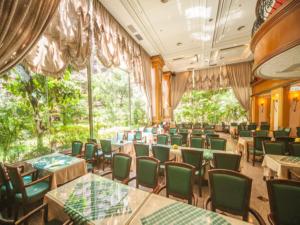 a dining room with tables and green chairs at Cheng Pao Hotel in Puli