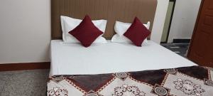 a bedroom with a bed with red and white pillows at श्रीजीर Kunj in Varanasi