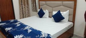 a bed with blue and white sheets and pillows at श्रीजीर Kunj in Varanasi