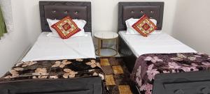 two beds sitting next to each other in a room at श्रीजीर Kunj in Varanasi