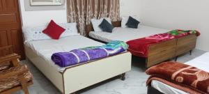 two beds in a room with colorful blankets on them at श्रीजीर Kunj in Varanasi