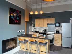 a kitchen with a large island with two bar stools at Louise Suite in Southport