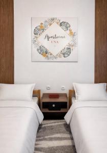 una camera da letto con due letti e un cartello con la scritta Metropolitan Inn di Apartman Una a Plužine