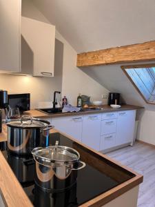 a kitchen with white cabinets and a counter top at Alpenheimat 1658 in Mittelberg +19 photos