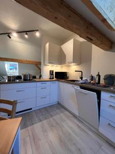 a kitchen with white cabinets and a wooden floor at Alpenheimat 1658 in Mittelberg