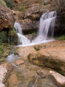 een waterval aan de kant van een berg met rotsen bij La Llum de Serra in Serra