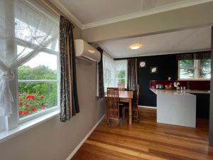 a kitchen and dining room with a table and a window at Cosy Corner in Hamilton