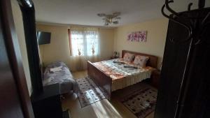 een kleine kamer met een bed en een raam bij Къща за гости Казакови in Kotel