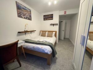 een slaapkamer met twee bedden, een bureau en een tafel bij Bota Property in Kidlington