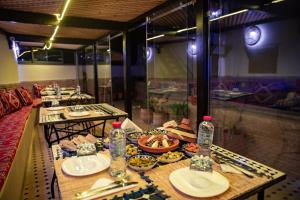 a table with plates of food and water bottles at Shauala Riad - Where History Lives in Fès +90 photos