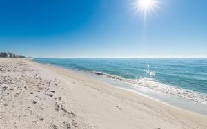 a beach with the sun shining over the water at Phoenix X 506 in Orange Beach