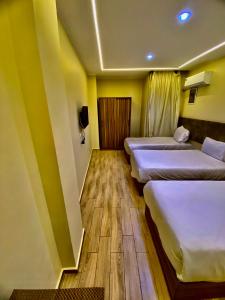 eine Reihe von Betten in einem Zimmer mit gelben Wänden in der Unterkunft Pyramidsfort & free pickup shuttle in Giza