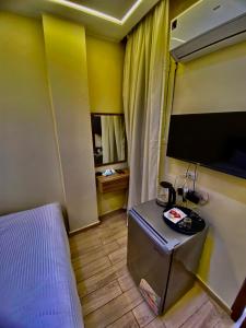ein Hotelzimmer mit Bett und Fernseher in der Unterkunft Pyramidsfort & free pickup shuttle in Giza