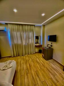 ein Zimmer mit einem Bett, einem Schreibtisch und einem Fernseher in der Unterkunft Pyramidsfort & free pickup shuttle in Giza