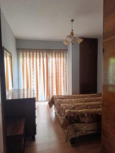 a bedroom with a bed and a desk and a window at Spacious Waterfront 3BR - 2Bath & 3 Panoramic Balconies - Pogradec, Lake Ohrid in Pogradec