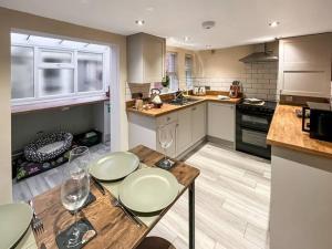 a kitchen with a table and two wine glasses at Tap Cottage in Burgh le Marsh +3 photos
