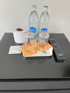 a table with two glasses and a remote control at The Rich Home in Nakhon Ratchasima
