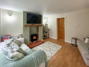 a living room with a couch and a fire place at Tap Cottage in Burgh le Marsh