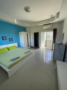 a bedroom with a bed and a tv in it at The Rich Home in Nakhon Ratchasima